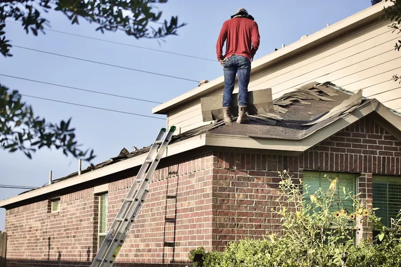 Professional roofer working on a residential roof in Andrews